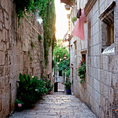 Blick in eine Gasse mit alten Steinhäusern und Wäscheleinen an den Fassaden, Korcula, Dalmatien, Kroatien