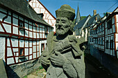 A statue and timbered houses in the Eifel, Rhineland-Palatinate, Germany