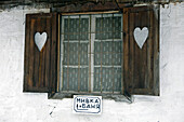 Fenster, Fensterläden und Herzchen. Das Schild weist in Richtung Dusche und Bad. Bulgarische Hüttenromantik. Demjanica Hütte, Pirin Gebirge. Bulgarien, Europa