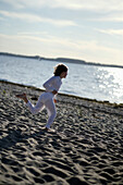 Mädchen rennt über den Ostseestrand, Travemünder Bucht, Schleswig-Holstein, Deutschland