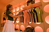 Young woman choosing a shirt in the exclusive shoe shop / shoe designer Könix, Zurich, Canton Zurich, Switzerland