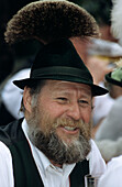 Man in traditional dress wearing hat with tuft of chamois hair, maypole festival in Flintsbach, Upper Bavaria, Bavaria, Germany