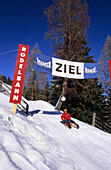 Sledging on the toboggan-run, reaching winning post, Kleinbergalm, Filzmoos, Salzburg, Austria