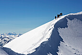 Eine Gruppe Menschen mit Skis und Snowboards steigen zum Gipfel des Hinterrugg auf, Churfirsten, Toggenburg, St. Gallen, Unterwasser, Alt St. Johann, Ostschweiz, Schweiz, Alpen, Europa