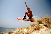 Mann beim Sandboarding, Tarifa, Andalusien, Spanien