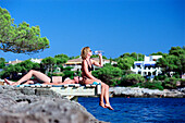 Two woman sitting on jetty, Porto Petro, Majorca, Spain