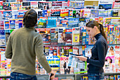 Zwei junge Leute in einem Zeitschriftengeschäft