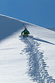 Back country skier tramping through deep snow, Engadin, Grisons, Switzerland