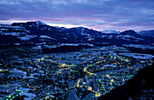 Blick auf die beleuchtete Innenstadt von Hallein mit den Bergen des Salzkammergutes, Salzburg, Österreich