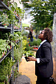 Eine Frau kauft Pflanzen in einem Gartengeschäft, Garden District, Washington DC, Vereinigte Staaten von Amerika, USA