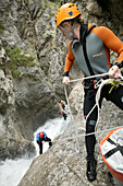 A group of people canyoning with guide, abseiling, Hachleschlucht, Haiming, Tyrol, Austria