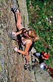Junge Frau klettert an Felswand, Urner Alpen, Kanton Uri, Schweiz, MR