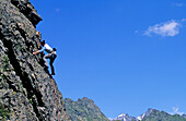 Junge Frau klettert an Felswand, Urner Alpen, Kanton Uri, Schweiz, MR