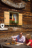 Young couple drinking cider, Lammersdorf hut (1650 m), Lammersdorf near Millstatt, Carinthia, Austria