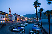 Hafen und Hafen Promenade mit Kirchenturm Santi Pietro Paolo im Hintergrund am Abend, Ascona, Lago Maggiore, Tessin, Schweiz