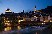 View over river Aare with mill slucie to Thun Castle and town church in the evening, Thun (largest garrison town of Switzerland), Bernese Oberland (highlands), Canton of Bern, Switzerland