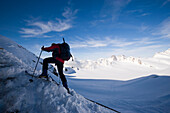 Man glacier hiking uphill at Monchsjoch, Grindelwald, Bernese Highlands, Canton of Bern, Switzerland