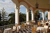 Chairs and tables on the sunlit terrace of Reids Hotel, Funchal, Madeira, Portugal