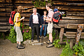 Couple talking to Anna and Josef Gruber, ower of the Karseggalm (1603 m, one of the oldest mountain hut in the valley), Grossarl Valley, Salzburg, Austria