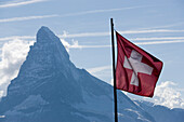 View from restaurant Fluhalp to the Matterhorn 4478 meters, Swiss flag in the foreground, Zermatt, Valais, Switzerland