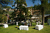 People sitting in the garden of the Grand Hotel Zermatterhof, Zermatt village, Zermatt, Valais, Switzerland