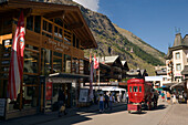 Red carriage of the Mont Cervin Palace parking in front of the Hotel, Zermatt village, Zermatt, Valais, Switzerland