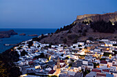 View over illuminated town at night to Acropolis, Lindos, Rhodes, Greece