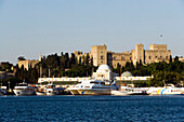 Ships and boats anchoring in Mandraki harbour (translated literally: fold), Palace of the Grand Master and Nea Agora in background, Rhodes Town, Rhodes, Greece