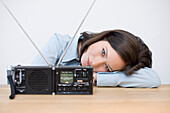 Young woman's head resting on table, world receiver in foreground