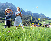 Girl and boy playing on mountain pasture, Leogang, Salzburg (state), Austria