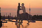 Molecular Men sculpture at River Spree with Alex TV Tower in Background, Berlin, Germany
