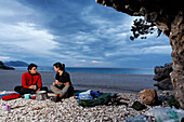 Adventurous trekking Il Sentiereo Selvaggio Blu, Sardinia, Golfo di Orosei, Italy. A young men and a young woman bivouac on the beach Cala Sisine, MR