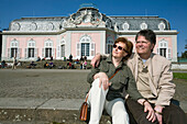 old couple sitting in front of the castle of Benrath, world heritage of UNESCO, sightseeing spot, local recreation area, Düsseldorf, state capital of NRW, North-Rhine-Westphalia, Germany