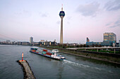 Passing container ship at the television tower, Rheinturm, with Düsseldorf skyline, Media Harbour, state capital of NRW, North-Rhine-Westphalia, Germany