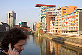 Young man phoning with a mobile phone, Media Harbour, Dusseldorf, North Rhine-Westphalia, Germany