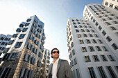 Junger Geschäftsmann vor neuer Zollhof, Architektur von Frank O.Gehry, Medienhafen in Düsseldorf, Nordrhein-Westfalen, Landeshauptstadt in NRW, Deutschland