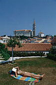 Woman sunbathing at Hotel Tarrini, Piran, Slovenia