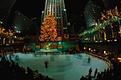 Rockefeller Center bei Nacht, Weihnachtsdeko, Lower Plaza mit Prometheus, Leute beim Schlittschuhlaufen im Vordergrund, Manhattan, New York, USA
