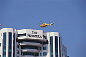 Helicopter landing on the roof of the Peninsula Hotel, Bangkok, Thailand