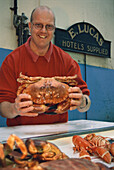 Mann verkauft Meeresfrüchte, Krabbe, Fischmarkt in St. Peter Port, Guernsey, Kanalinseln, Großbritannien