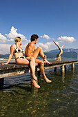 Family at lake Attersee, girl cartwheeling on jetty, Salzkammergut, Upper Austria, Austria