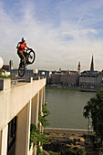 Radfahrer springt auf Rathaus, im Hintergrund der Dom, Linz, Oberösterreich