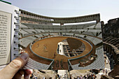 View through transparent page of a travel guide, Colosseum, Rome, Italy