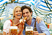 Couple with beer and pretzel in a beer tent