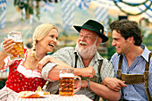 Couple and a mature man swaying left and right in a beer tent