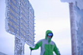 Frozen ski slope sign, skier in background, Sunshine Village ski resort, Banff, Alberta, Canada