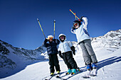 Three children on a ski slope, Lazaun Upper Station, Schnalstal, South Tyrol, Italy
