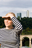 Junge Frau blickt in die Ferne, Hochhäuser im Hintergrund, Luxemburg, Luxemburg