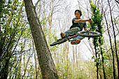 Junger Mann springt im Wald mit BMX, Mindelheim, Bayern, Deutschland