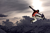 Snowboarder springt im Sonnenuntergang, See, Tirol, Österreich